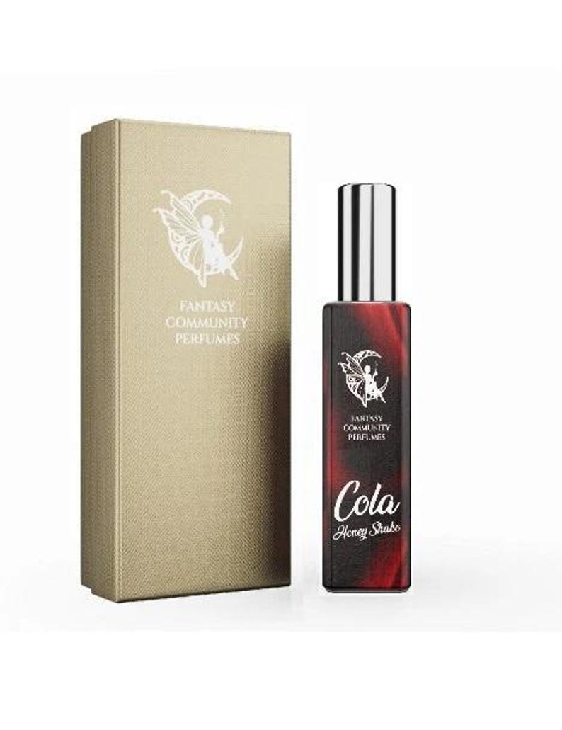 May include: A red and black bottle of perfume with a silver cap. The bottle has a white label with the text "Fantasy Community Perfumes" and "Cola Honey Shake".