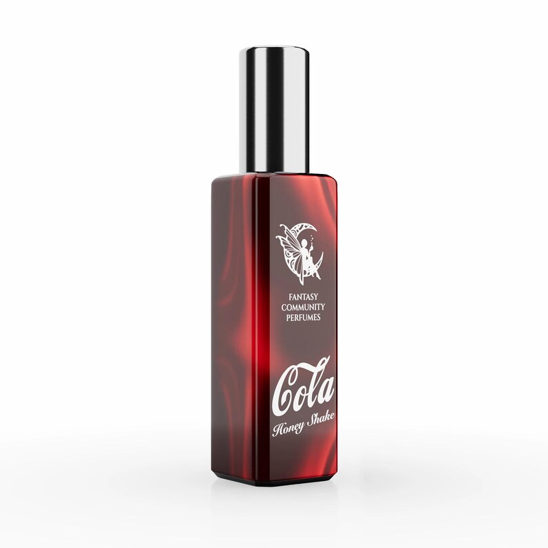 May include: A red glass bottle of perfume with a silver cap. The bottle has a white label with the text "Fantasy Community Perfumes" and "Cola Honey Shake".