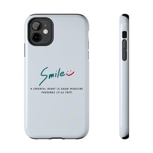 Könnte beinhalten: Hellblaue Handyhülle mit dem Wort "Smile" in türkisfarbener Schrift und einem roten Smiley. Darunter steht der Text "A cheerful heart is good medicine Proverbs 17:22 (NIV)".