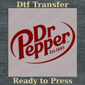 Puede incluir: Una transferencia DTF del logotipo de Dr Pepper rojo, lista para planchar. El logotipo presenta el nombre de la marca en una fuente estilizada con un acento curvo y el texto "Est. 1885". Las palabras "Ready to Press" están en la parte inferior.