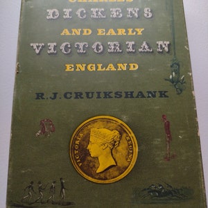 May include: A vintage book titled "Charles Dickens and Early Victorian England" by R.J. Cruikshank. The cover is green with gold lettering and a gold coin illustration featuring a profile. The book has illustrations and is slightly worn.