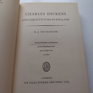 May include: Open book titled "CHARLES DICKENS AND EARLY VICTORIAN ENGLAND" by R.J. Cruikshank. The book includes 64 illustrations in photogravure, 37 text illustrations in line, and 14 Isotype charts in color. Published by Sir Isaac Pitman and Sons, Ltd. in London.
