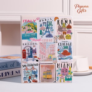 May include: A white notebook with colorful illustrations of various cities, including Italy, Paris, Rome, London, Lisbon, Chicago, San Francisco, Portugal, and Miami. The notebook has the text "ITALY", "PARIS", "ROMA", "LONDON", "LISBON", "CHICAGO", "SAN FRANCISCO", "PORTUGAL", and "MIAMI".