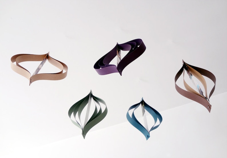 May include: Five paper ornaments in different colors, including brown, purple, green, and blue. The ornaments are made of folded paper and have a unique, teardrop shape.