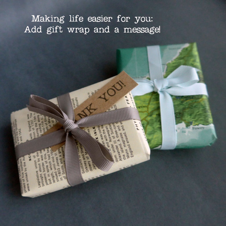 May include: Two small gifts wrapped in brown paper and a green map. One gift has a grey ribbon and a brown tag that says "Thank You!" The other gift has a light blue ribbon.