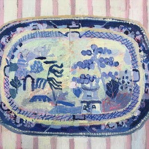 May include: A blue and white ceramic platter with a floral design. The platter has a yellow rim and is decorated with a repeating pattern of flowers and leaves.