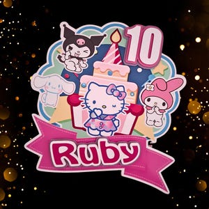 May include: A vibrant birthday cake topper with Hello Kitty and friends. The design includes a cake with a lit candle, the number 10, and a banner that reads "Ruby". The characters are set against a blue and yellow background.