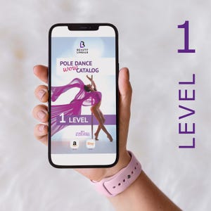 Op de afbeelding: Een smartphone die een paarse en witte pole dance-catalogus weergeeft met de tekst "Pole Dance Wow Catalog" en "1 Level". De catalogus toont een vrouw in een roze en paarse outfit die een pole dance-move uitvoert. De telefoon wordt vastgehouden door een hand met een roze smartwatch.