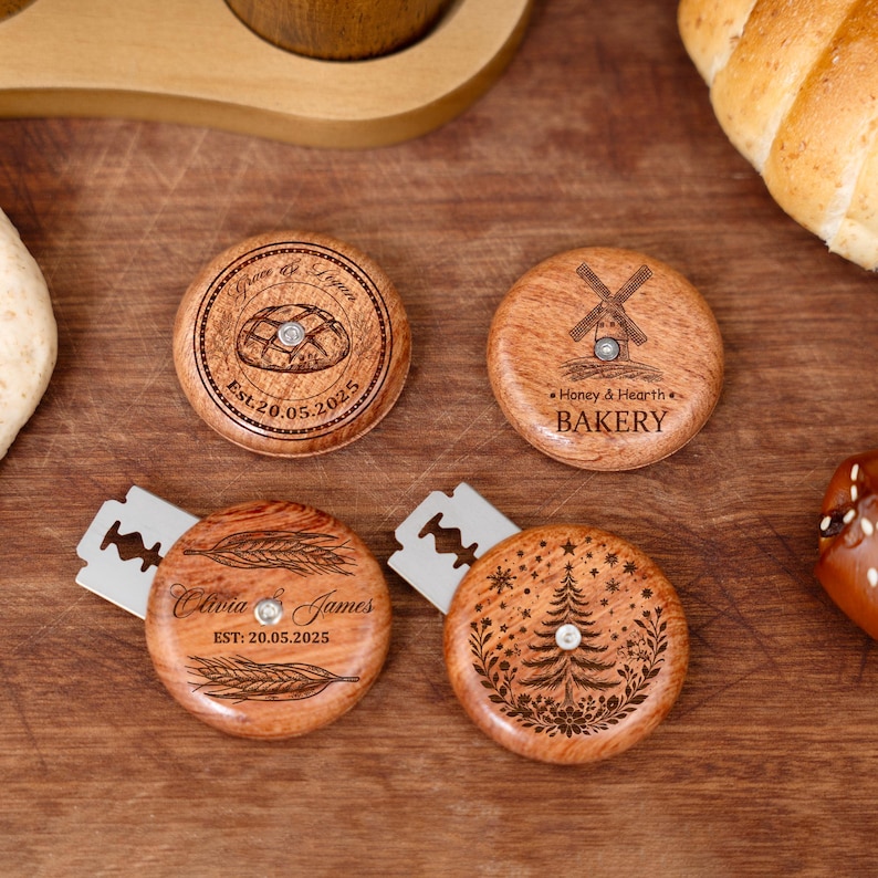 Peut inclure: Quatre lames &agrave; pain en bois avec des motifs grav&eacute;s. L'une pr&eacute;sente un pain et le texte "Grace & Logan", une autre un moulin &agrave; vent et le texte "Honey & Hearth BAKERY". Les deux autres ont du bl&eacute; et un motif de sapin de No&euml;l.