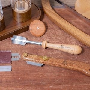 May include: Two craft knives with wooden handles and metal blades. The blades are engraved with the word "Katherine".