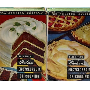 May include: Two vintage cookbooks, "Meta Given's Modern Encyclopedia of Cooking," are shown. The covers feature illustrations of cake and pies. The top of the books read "New Revised Edition."