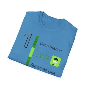 May include: A light blue t-shirt featuring the number 7, Japanese text, and the words "Ueno Station" and "Yamanote Line." The design includes a green and white graphic of a train.