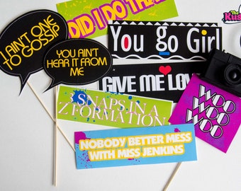 May include: A set of 10 colorful photo booth props with fun sayings like "I ain't one to gossip", "You go girl", and "Give me love". The props are printed on cardstock and have sticks attached. There is also a black camera prop.