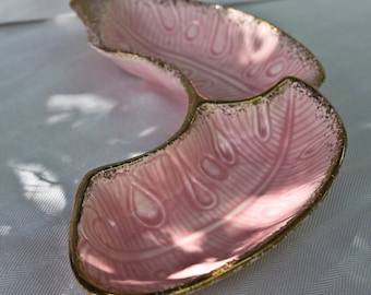 Può includere: Un piatto da portata rosa diviso con un bordo dorato. Il piatto presenta un motivo a forma di piuma in rilievo all'interno. Il piatto è in ceramica o porcellana ed è probabilmente vintage.