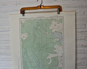 May include: A vintage map of the Cheakamus River in British Columbia, Canada. The map is printed on cream-colored paper and shows the river winding through a green forested area. The map is titled "Cheakamus River" and includes a legend and scale.