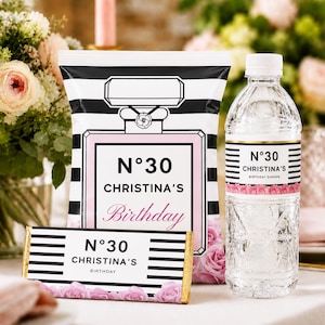 May include: A custom party favour set featuring a snack bag, a candy bar wrapper, and a water bottle label. Each item displays black and white horizontal stripes, pink rose graphics, and the text N°30 CHRISTINA'S Birthday in a modern font.