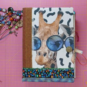 Junk Journal Hardcover, 15 x 22cm, 72 Seiten, Pappeinband mit Stoff bezogen, viele Taschen & Steckplätze, Gummibandverschluss, Giraffenmotiv