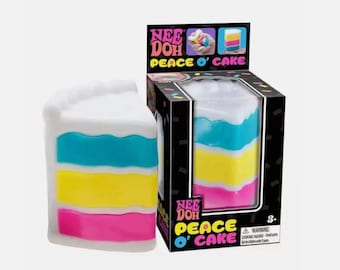 May include: A Nee Doh Peace O' Cake squishy toy shaped like a slice of cake with white frosting on top and three horizontal layers in bright turquoise, yellow, and pink. The product is displayed next to its black box with colorful text.
