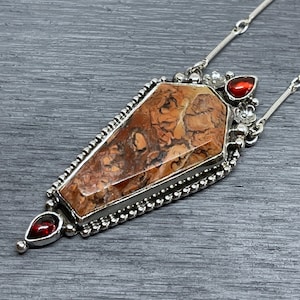 coffin shaped gemstone silver pendant with flowers and garnets
