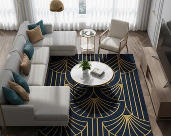 May include: An overhead shot of a modern living room featuring a large gray sectional sofa, a navy blue rug with a gold geometric design, and a white marble coffee table. The room is well-lit with a gold floor lamp and sheer white curtains. The rug has the text "ECLATIQUE RUG".
