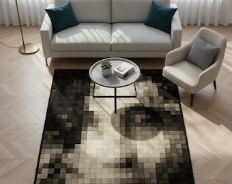 May include: A rectangular rug with a pixelated design in black, grey, and beige. The rug features a large, abstract face pattern. The words "Eclatque Rug" are printed on the bottom right corner. The rug is in a living room setting with a sofa and armchair.