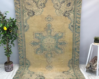 May include: A large rectangular area rug featuring a central medallion and intricate border patterns in shades of muted beige, teal, and charcoal gray. The design includes symmetrical floral and geometric motifs across the entire surface.