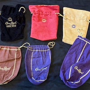 以下が含まれることがあります： 異なる生地と色で作られた6つの巾着袋。すべての袋は、クラウンロイヤルロゴと「クラウンロイヤル」と「Cask No. 16」の文字で飾られています。