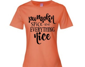 May include: An orange t-shirt with the phrase "pumpkin spice and everything nice" in black script. The shirt has short sleeves and a crew neck, perfect for fall.