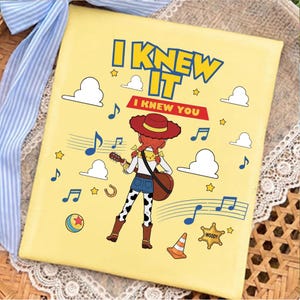 May include: A square yellow canvas featuring a cartoon cowgirl playing a guitar. The text reads I KNEW IT and I KNEW YOU. The design includes blue musical notes, white clouds, yellow stars, a colorful ball, a traffic cone, and a sheriff badge.