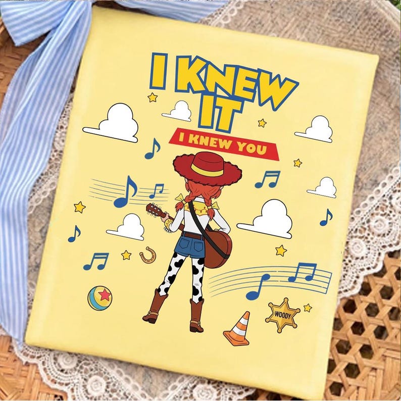 May include: A square yellow canvas featuring a cartoon cowgirl playing a guitar. The text reads I KNEW IT and I KNEW YOU. The design includes blue musical notes, white clouds, yellow stars, a colorful ball, a traffic cone, and a sheriff badge.