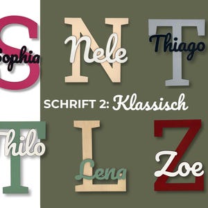 May include: Wooden letters in various colors, each with a name in a contrasting color. The letter "S" is magenta with "Sophia" in black. The text "SCHRIFT 2: Klassisch" is also visible.