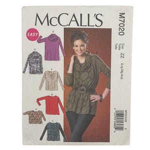 May include: McCall's M7020 sewing pattern envelope for a long-sleeve top with a cowl neckline. The front displays illustrations of six variations of the top in different colors and patterns, alongside a photograph of the top in olive green.