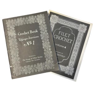 May include: Two softcover instructional books with dark gray covers and white text. The left book is titled Crochet Book Edgings & Insertions No 1. The right book is titled FILET CROCHET volume 4. Both feature intricate white lace-patterned borders.