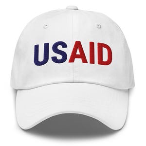 May include: White baseball cap with the word "USAID" embroidered in blue and red.