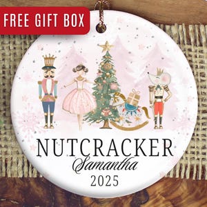 May include: Round ceramic Christmas ornament featuring a Nutcracker theme. The design includes illustrations of a nutcracker, ballerina, Christmas tree, and mouse king. The ornament has the text "Nutcracker", a name, and the year 2025.