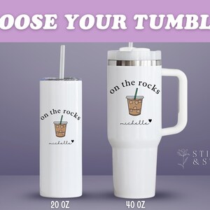 May include: White tumblers with the text "CHOOSE YOUR TUMBLER". One is a 20 oz skinny tumbler with a straw, and the other is a 40 oz tumbler with a handle. Both have an "on the rocks" design with a coffee drink.