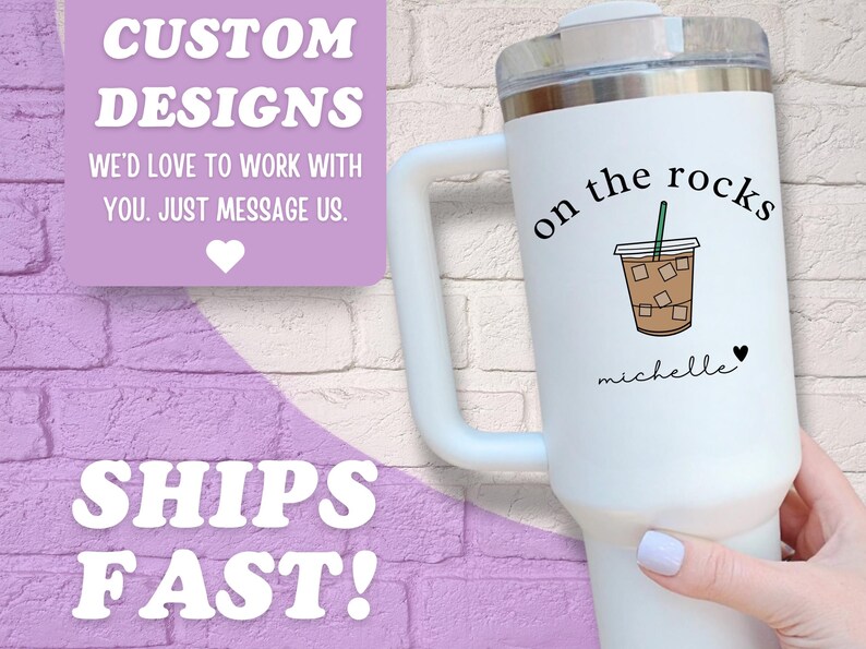 May include: White insulated tumbler with a handle, featuring a graphic of an iced coffee with the words "on the rocks" and a name. The tumbler also has the text "Custom Designs" and "Ships Fast!"