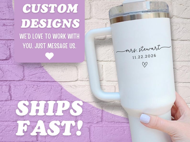 May include: White insulated tumbler with a handle, featuring the text "mrs. stewart" and the date 11.22.2026, along with a heart symbol. The tumbler has a clear lid and is held by a person. The image also includes text that says "CUSTOM DESIGNS" and "SHIPS FAST!"