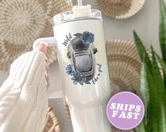 May include: White insulated tumbler with a handle, featuring a welding mask design with blue floral accents and the text "Weld like a girl." The tumbler has a clear lid and a straw.