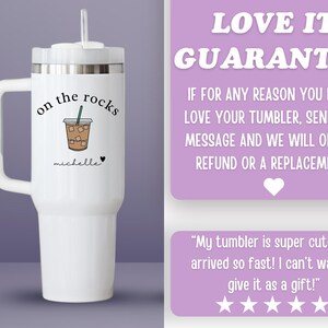 May include: White tumbler with a handle, a lid, and a straw. The tumbler has the words "on the rocks" and a drawing of an iced coffee drink. The name "michelle" is written below the drawing, with a heart symbol.