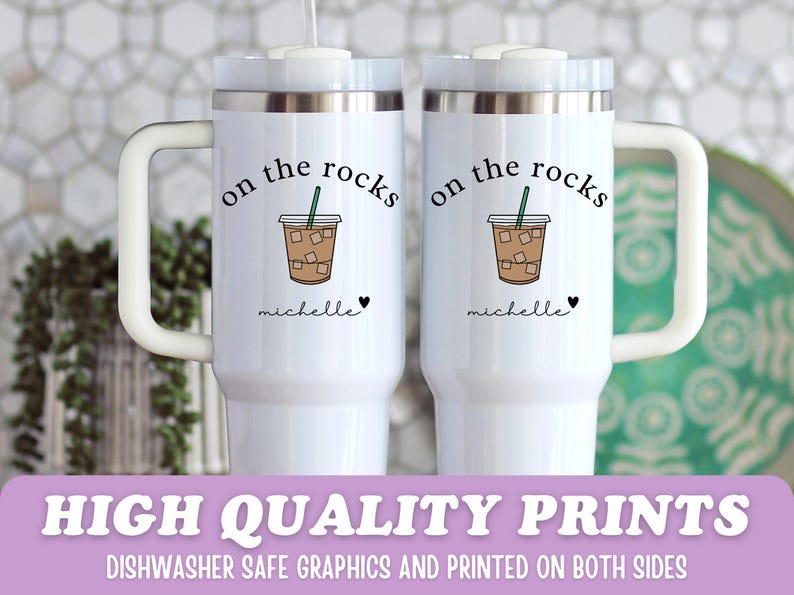 May include: Two white travel mugs with handles, each featuring the text "on the rocks" above a graphic of an iced coffee. Below the graphic is the name "michelle" and a heart. The bottom of the image reads "HIGH QUALITY PRINTS".
