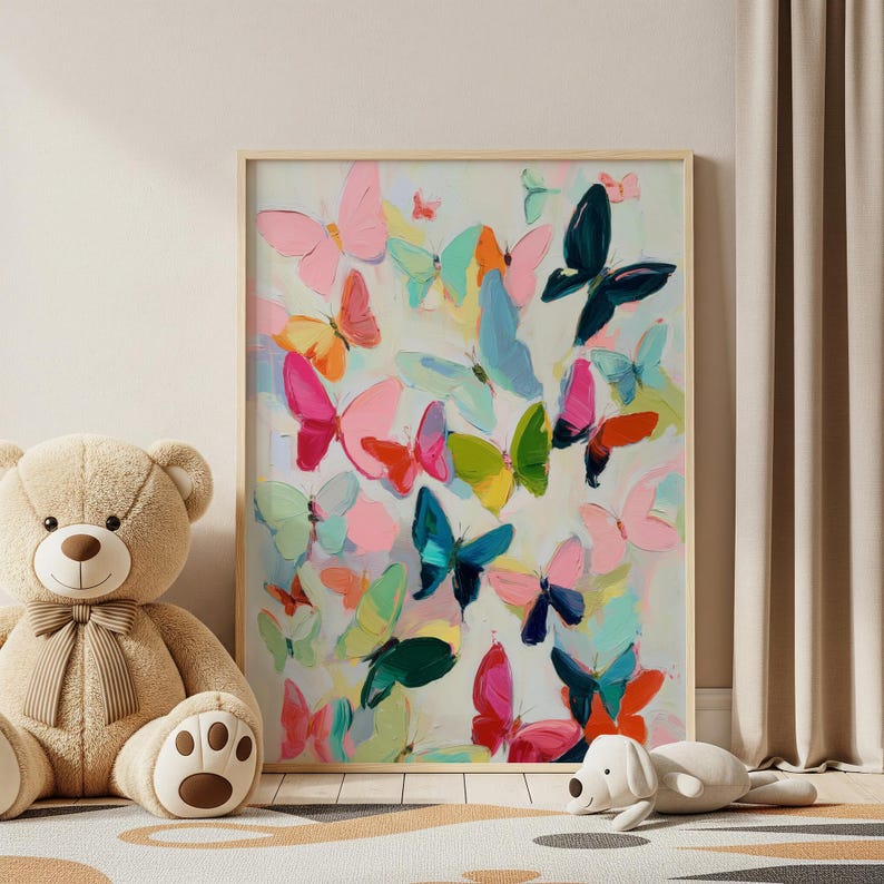 May include: A framed artwork depicting numerous painted butterflies in a variety of colours, including pink, blue, green, and orange. The butterflies are set against a light background, creating a colourful and whimsical scene. The artwork is displayed near a teddy bear and a stuffed dog.