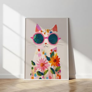 Könnte beinhalten: Gerahmter Kunstdruck mit einer skurrilen Katze mit rosa Sonnenbrille. Die weiße Katze hat bunte Punkte und florale Akzente. Das Kunstwerk zeigt rosa, orange und grüne Blumen und schafft ein fröhliches Design.