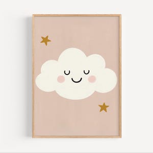 Pode incluir: Uma impressão artística emoldurada com uma nuvem sorridente com bochechas rosadas e duas estrelas douradas sobre um fundo rosa blush. A nuvem tem uma boca preta sorrindo e olhos fechados. A obra de arte está em uma moldura de madeira clara.