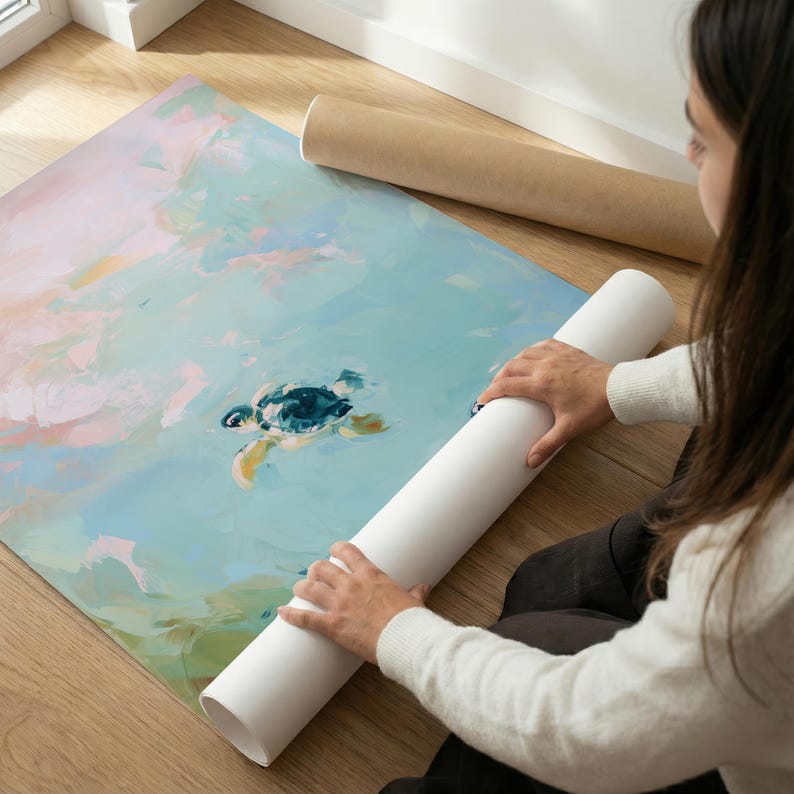 May include: An art print featuring a sea turtle swimming in the ocean. The artwork has a watercolor style with shades of blue, green, yellow, and pink. The print is rolled up with a white tube.