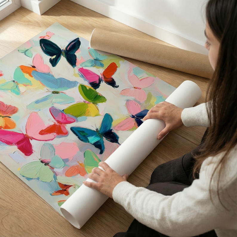 May include: A vibrant butterfly art print with butterflies in pink, blue, green, and orange. The butterflies are painted on a white background. The print is rolled up with a white tube.