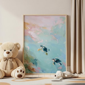 May include: An abstract art print featuring two sea turtles swimming in turquoise water. The artwork has a light wooden frame and is surrounded by a beige teddy bear, a white dog plush toy, and a patterned rug. The painting has soft pink and blue hues.
