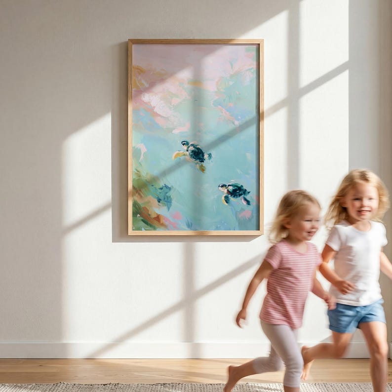 May include: A framed art print featuring an abstract painting of two sea turtles swimming in turquoise water. The artwork has a light wood frame and is displayed on a white wall. Two young children are running in the foreground.