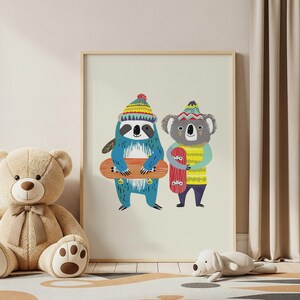 May include: A framed print featuring two cartoon animals: a blue sloth and a gray koala, both wearing colorful knit hats and sweaters. The sloth holds a skateboard, while the koala holds a red skateboard. The artwork has a playful, whimsical style.