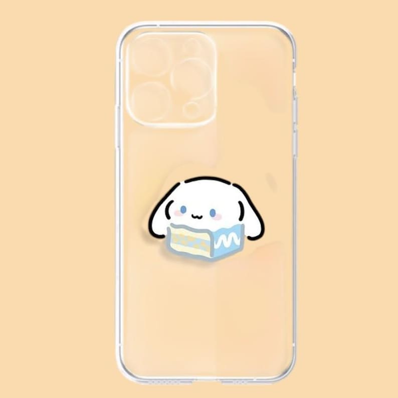 May include: Clear phone case featuring a cartoon character with a white body, black outlines, and blue accents. The character is holding a blue and yellow cake. The case is designed to fit a smartphone.